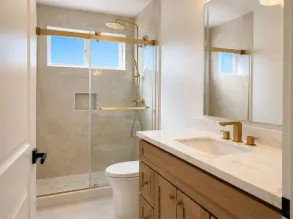 A bathroom fully rebuilt after water damage, with new drywall, tile, and fixtures.