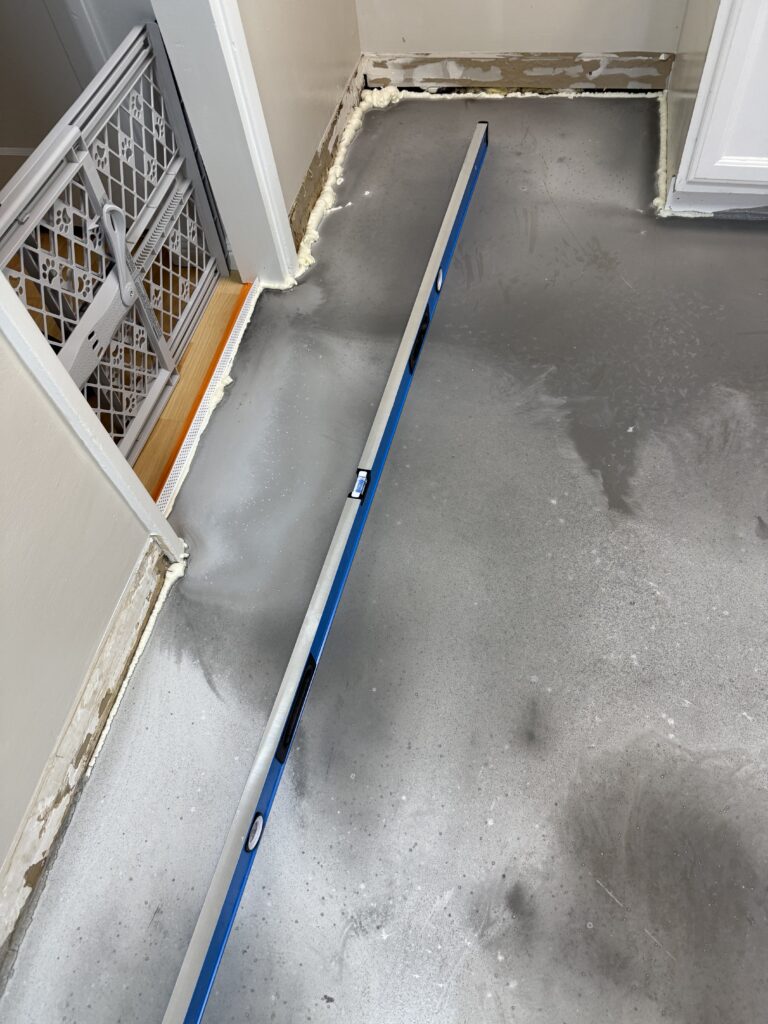 Checking subfloor flatness with professional level before tiling