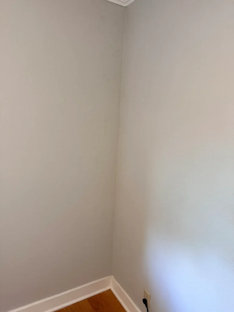 The final view of the restored wall. The lath and plaster section has been repaired, textured to match, and freshly painted to blend with the original wall.