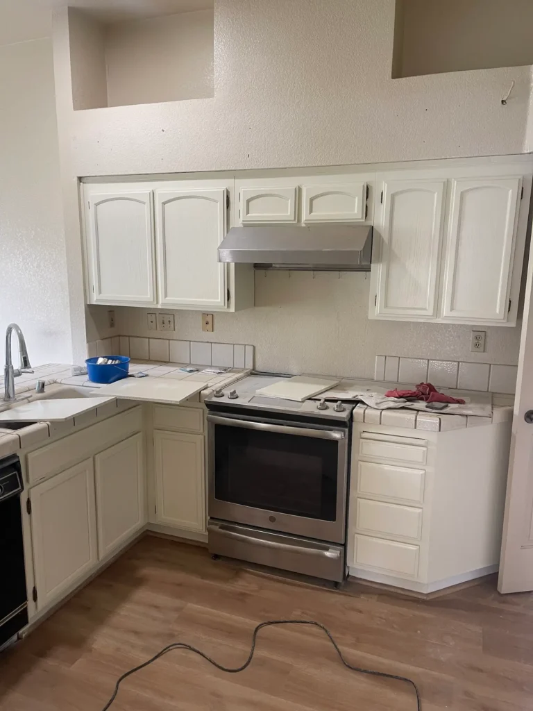 Kitchen after cabinet painting: former oak cabinets painted a soft white, upper and lower cabinets with a smooth, even finish