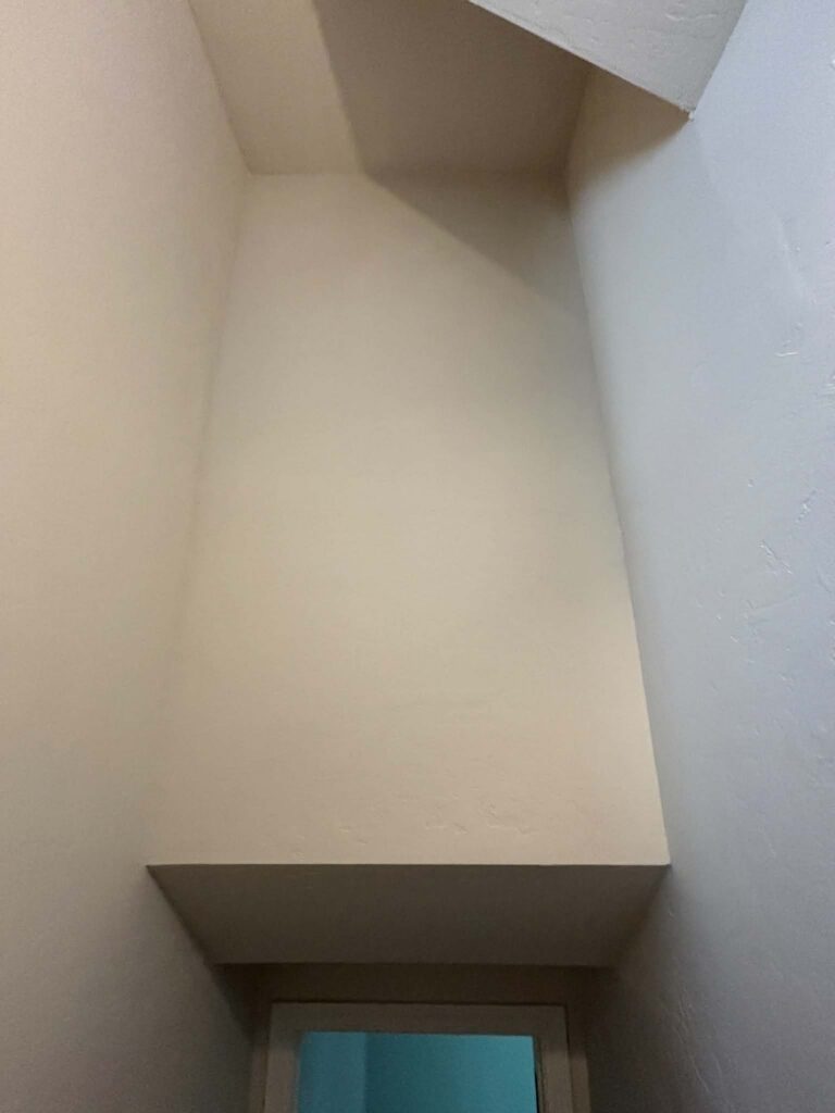 Seamless textured transition where the new partition wall meets the existing ceiling