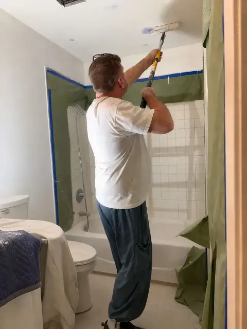 Sergei of Fresh Start Renovations working on a bathroom ceiling in San Jose